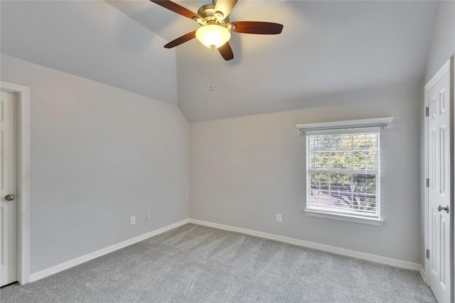 unfurnished room with vaulted ceiling, ceiling fan, baseboards, and light colored carpet