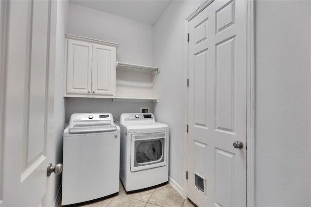 clothes washing area with cabinet space, baseboards, washer and dryer, and light tile patterned flooring