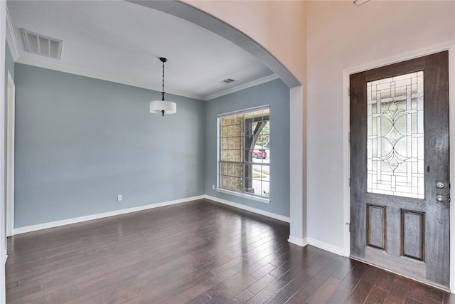 foyer with arched walkways, dark wood-style flooring, visible vents, baseboards, and crown molding