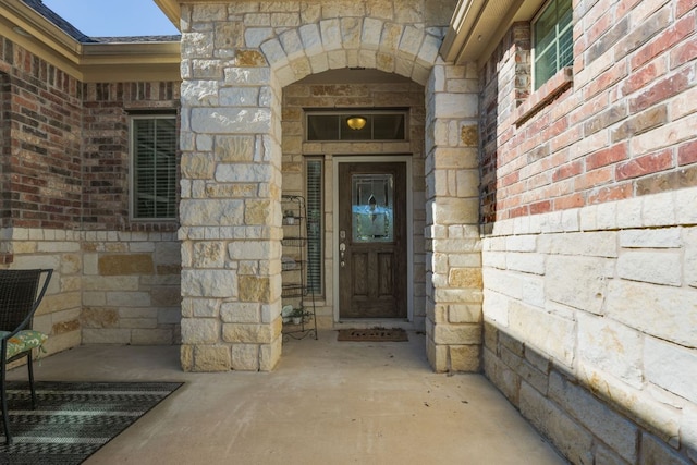 doorway to property with stone siding and brick siding