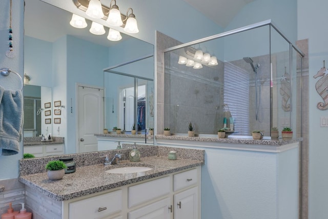 bathroom with a shower stall, vanity, and an inviting chandelier