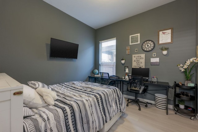 bedroom with wood finished floors and baseboards