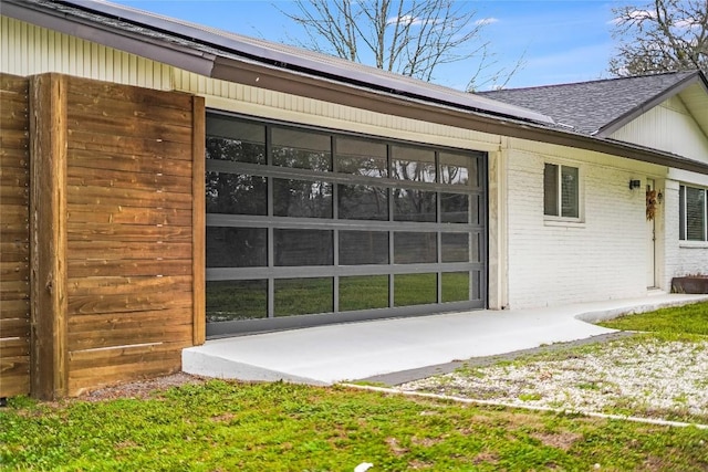 exterior space with solar panels, brick siding, and a shingled roof