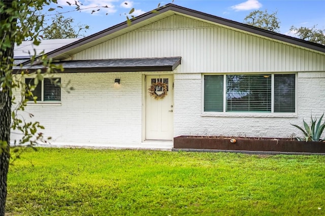 single story home featuring brick siding and a front yard