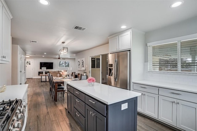 kitchen with visible vents, open floor plan, light countertops, appliances with stainless steel finishes, and dark wood finished floors