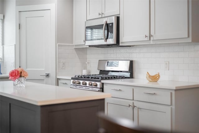 kitchen with appliances with stainless steel finishes, light countertops, and decorative backsplash