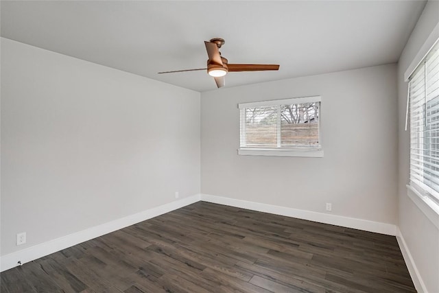 empty room featuring dark wood-style floors, a ceiling fan, and baseboards