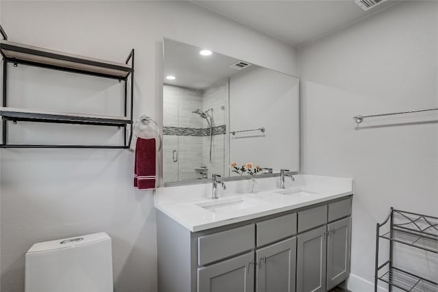 bathroom with a stall shower, visible vents, a sink, and double vanity