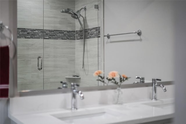 full bathroom featuring a tile shower and a sink