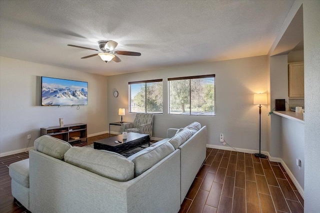 living room featuring wood tiled floor, baseboards, and a ceiling fan