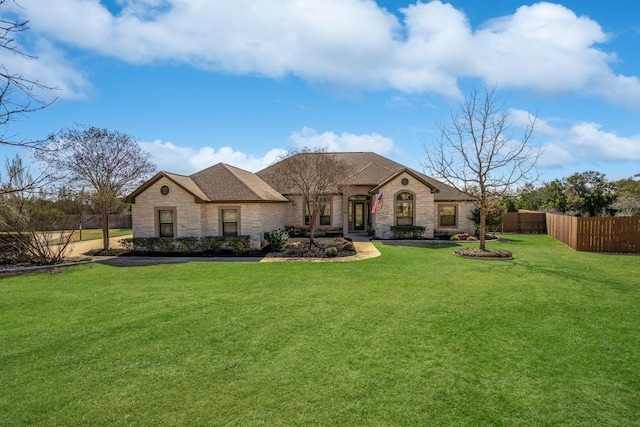 french country inspired facade with a front yard and fence