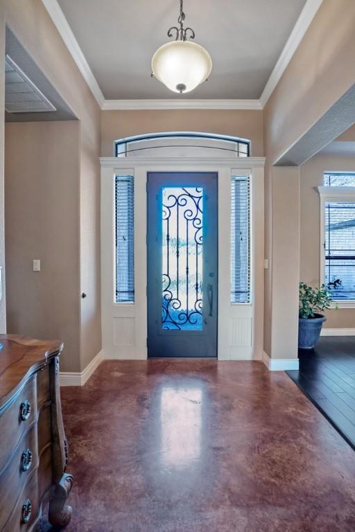 entryway featuring ornamental molding, concrete floors, and baseboards