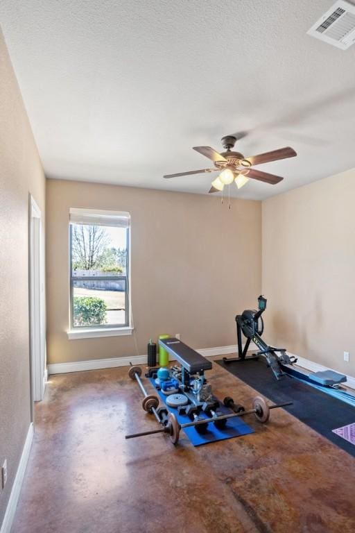 exercise room with a ceiling fan, baseboards, visible vents, and a textured ceiling