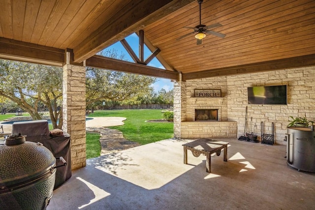 view of patio with an outdoor stone fireplace and a ceiling fan