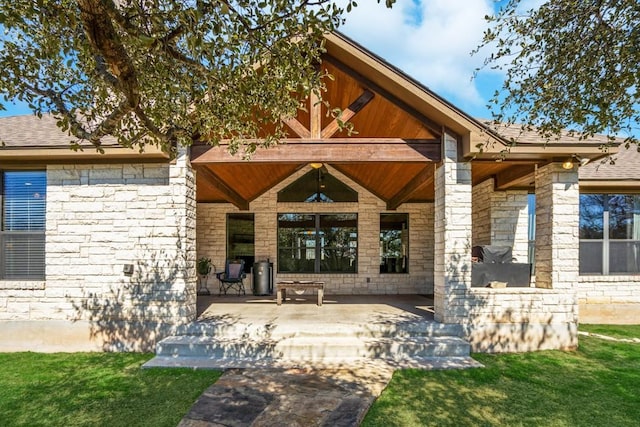 doorway to property with a shingled roof and stone siding