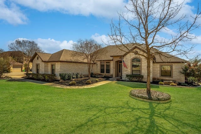 view of front facade with stone siding, a shingled roof, and a front yard