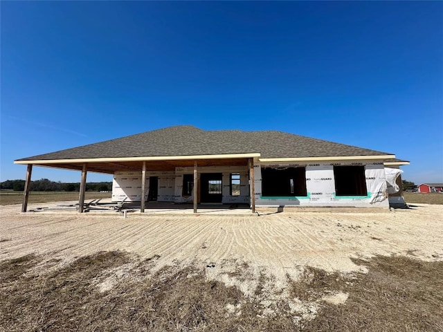 back of property with a shingled roof