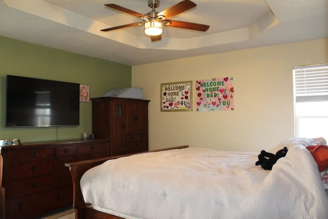 bedroom featuring a tray ceiling and a ceiling fan