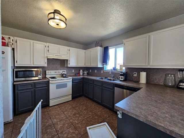 kitchen featuring stainless steel appliances, backsplash, a sink, and under cabinet range hood