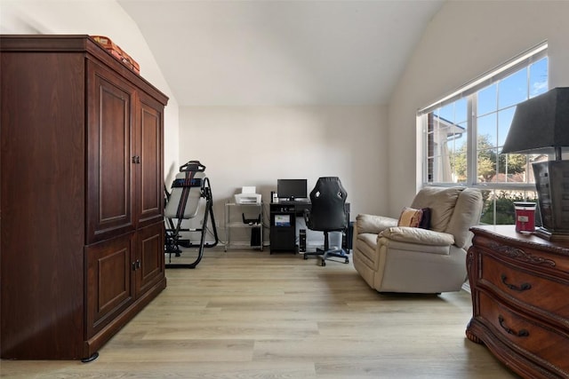 office with lofted ceiling and light wood-type flooring