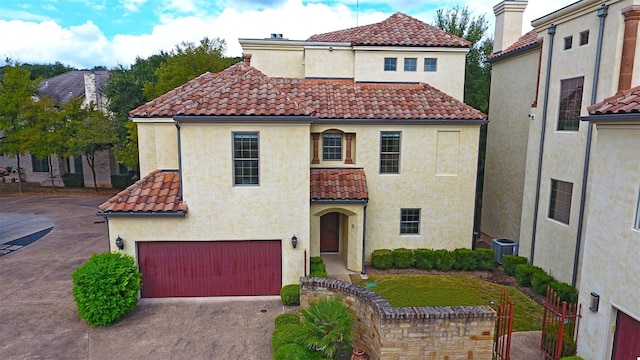 mediterranean / spanish-style home with driveway, a tile roof, a garage, and stucco siding