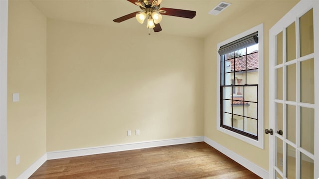 spare room featuring baseboards, visible vents, wood finished floors, and french doors