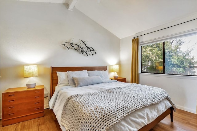 bedroom featuring vaulted ceiling with beams, wood finished floors, and baseboards