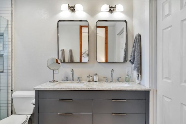 full bathroom with a sink, toilet, and double vanity