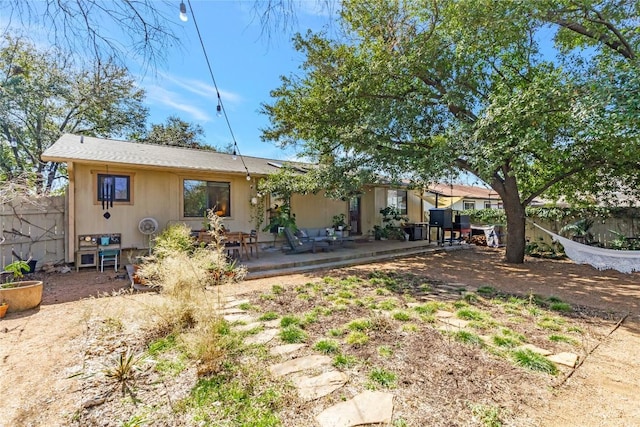 rear view of house featuring a patio and fence