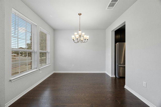 unfurnished room featuring dark wood-style floors, baseboards, visible vents, and an inviting chandelier