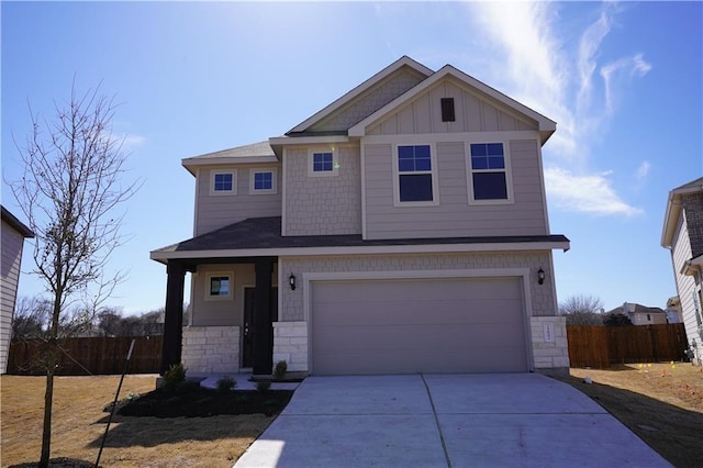 view of front facade with a garage, fence, driveway, stone siding, and board and batten siding