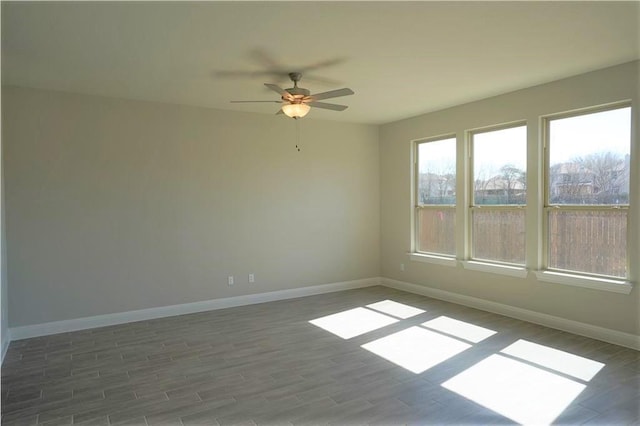 unfurnished room featuring ceiling fan, wood finished floors, and baseboards