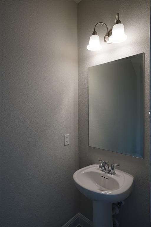 bathroom featuring a sink and baseboards