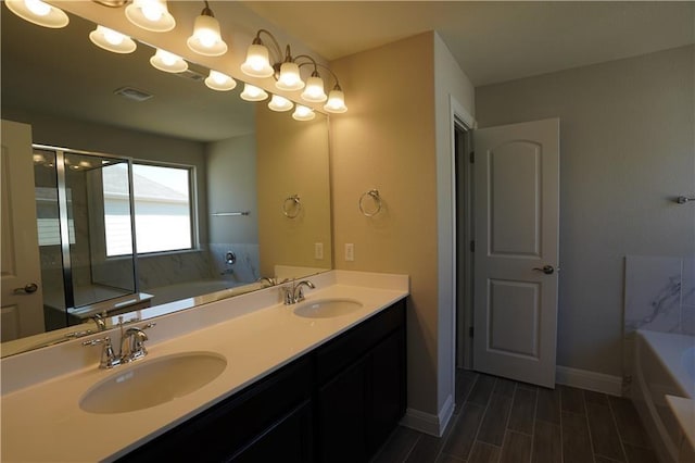 full bathroom featuring a bath, double vanity, baseboards, and a sink