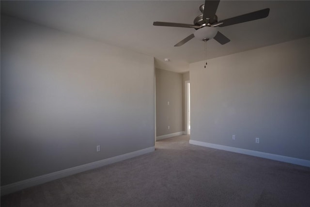 carpeted spare room with baseboards and a ceiling fan