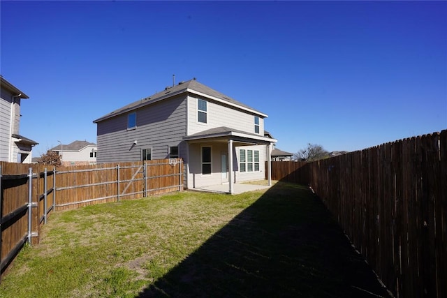 back of property with a patio area, a fenced backyard, and a yard