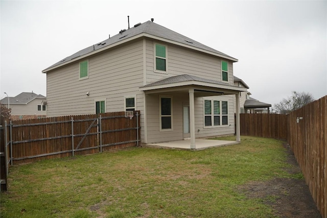 rear view of property featuring a patio area, a fenced backyard, and a lawn