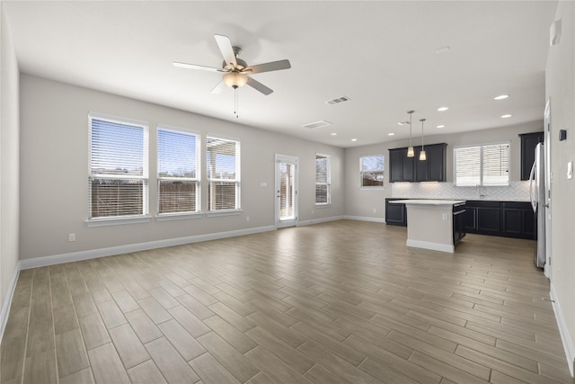 interior space with ceiling fan, recessed lighting, visible vents, baseboards, and light wood-type flooring