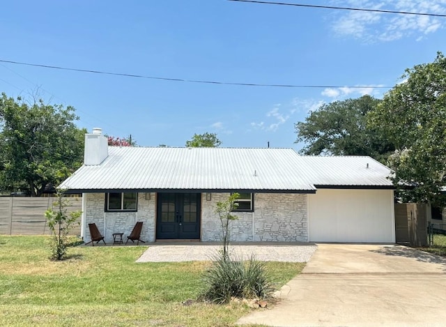 ranch-style house featuring french doors, a chimney, a front yard, fence, and metal roof