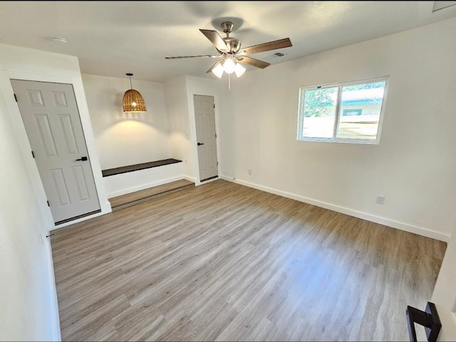 unfurnished room with ceiling fan, baseboards, and wood finished floors