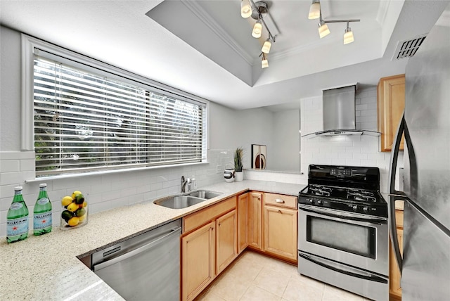 kitchen with stainless steel appliances, a sink, decorative backsplash, wall chimney exhaust hood, and a raised ceiling