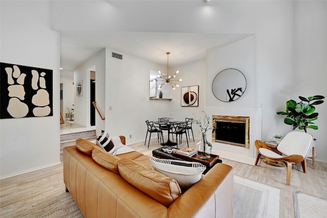 8102 Baywood Dr Unit A, Austin, TX 78759 - living room with light wood-style floors, a chandelier, and a glass covered fireplace