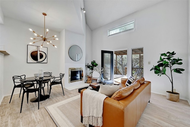 8102 Baywood Dr Unit A, Austin, TX 78759 - living room with light wood-style floors, high vaulted ceiling, a glass covered fireplace, and a chandelier