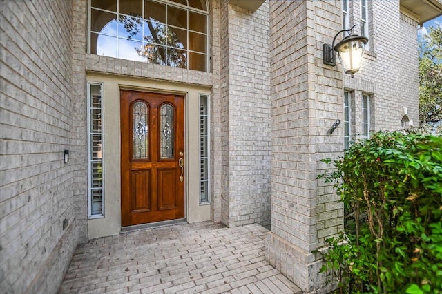 view of exterior entry with brick siding