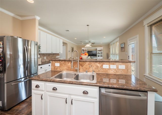 kitchen with stainless steel appliances, a sink, backsplash, and ornamental molding