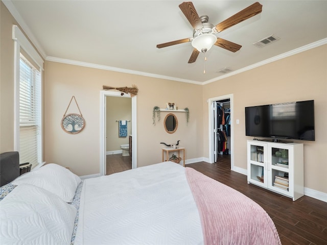 bedroom featuring dark wood-type flooring, visible vents, crown molding, and a spacious closet