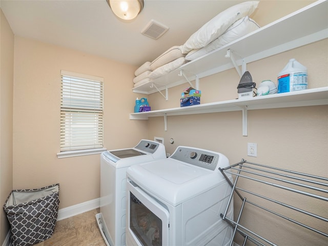 laundry room with laundry area, baseboards, visible vents, and separate washer and dryer