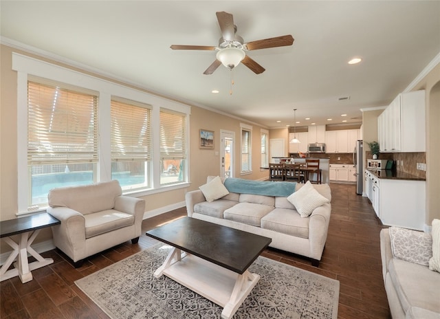 living area with crown molding, baseboards, dark wood-style flooring, and recessed lighting