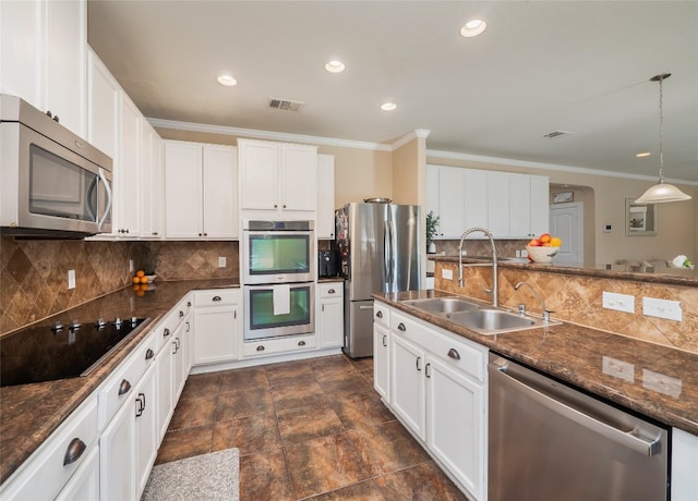 kitchen featuring stainless steel appliances, tasteful backsplash, visible vents, ornamental molding, and a sink