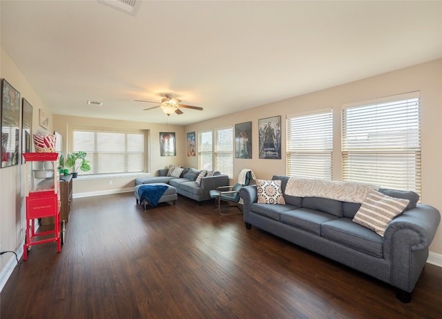 living room featuring dark wood-style floors, visible vents, baseboards, and a ceiling fan